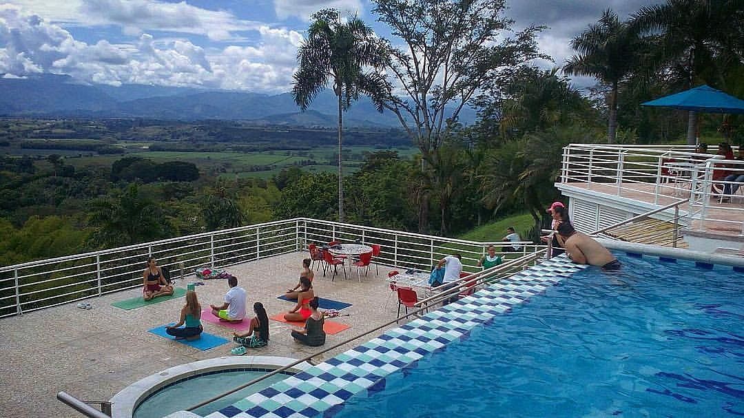 Un grupo de personas está haciendo yoga frente a una gran piscina.