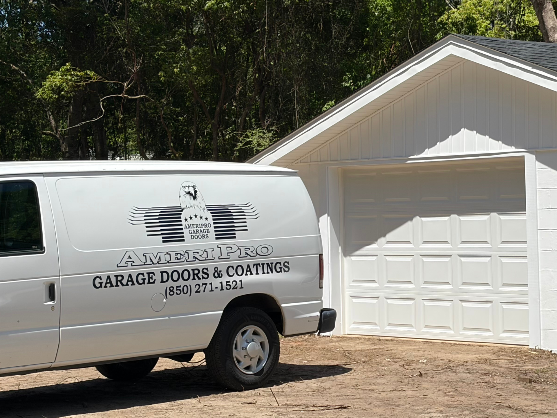 White garage door installation van parked in front of a light-colored house garage.