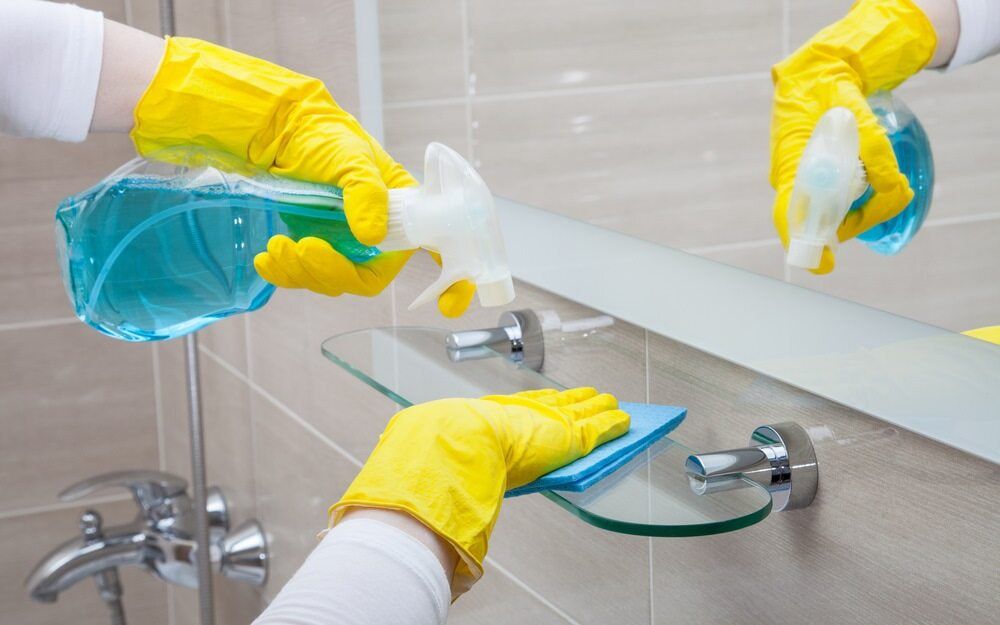 Hands in Yellow Gloves Cleaning a Bathroom Mirror — Cleanaroo Property Services in Conder, ACT