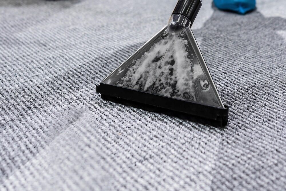 Carpet Cleaner Head Extracting Cleaning Solution From a Gray Carpet — Cleanaroo Property Services in Conder, ACT