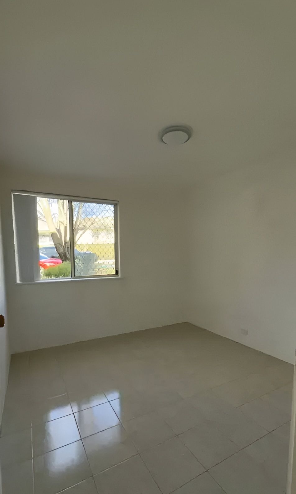 Empty Room With Square Tile Floors, Window, and Overhead Light — Cleanaroo Property Services in Conder, ACT