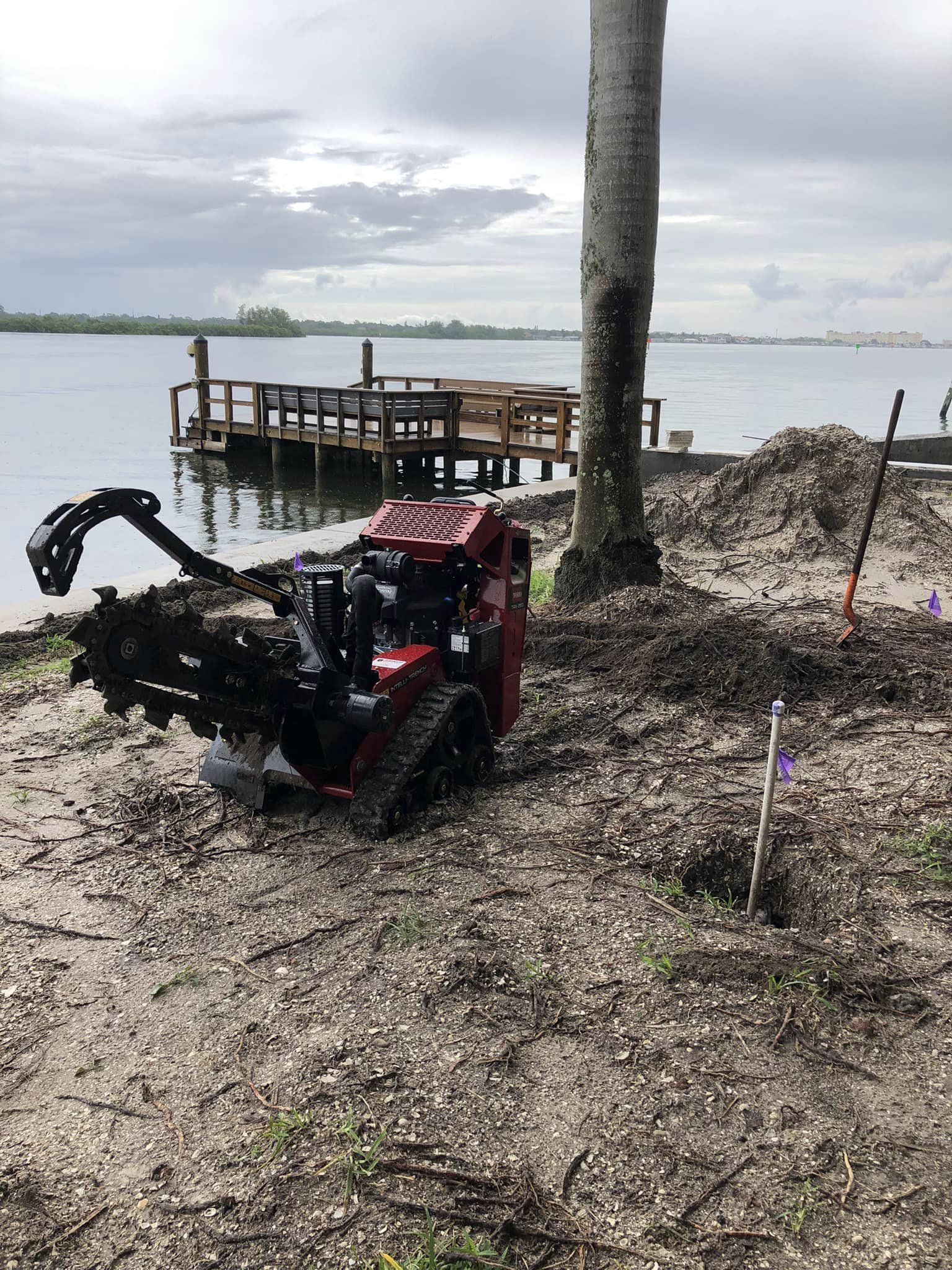 A machine is sitting on the ground next to a body of water.