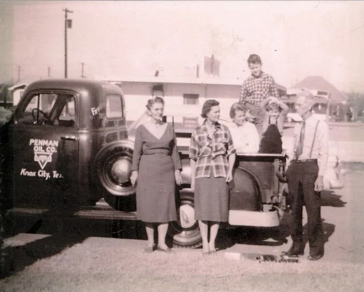 People pose with a truck, possibly a business vehicle.