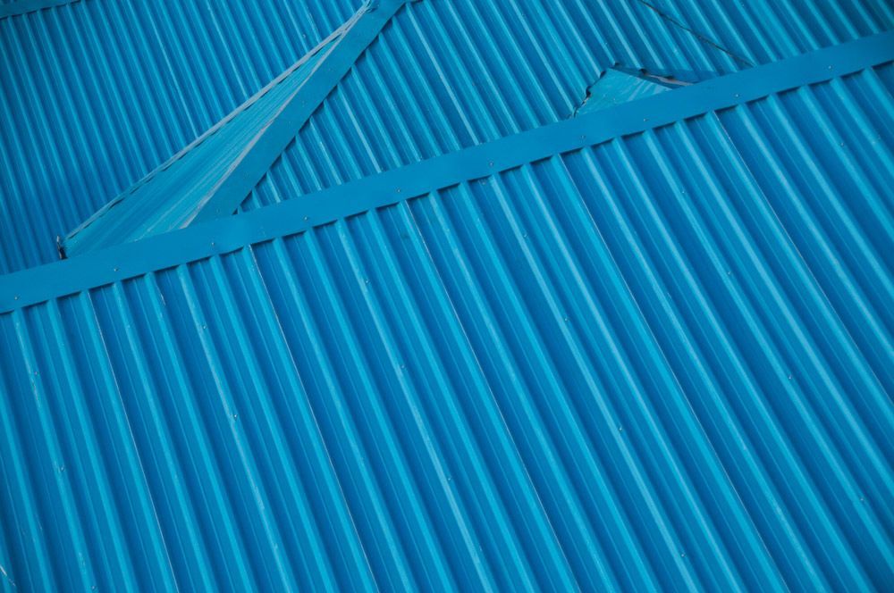 A Close Up Of A Blue Corrugated Metal Roof — Topflite Roofing In Jervis Bay, NSW