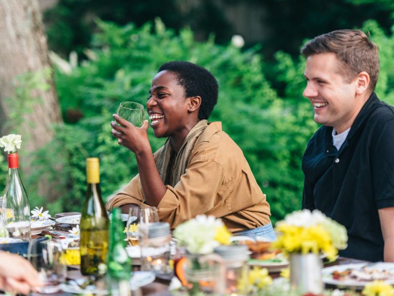 A group of people are sitting at a table eating and drinking.