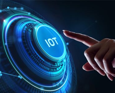 A person is pointing at a button that says iot
