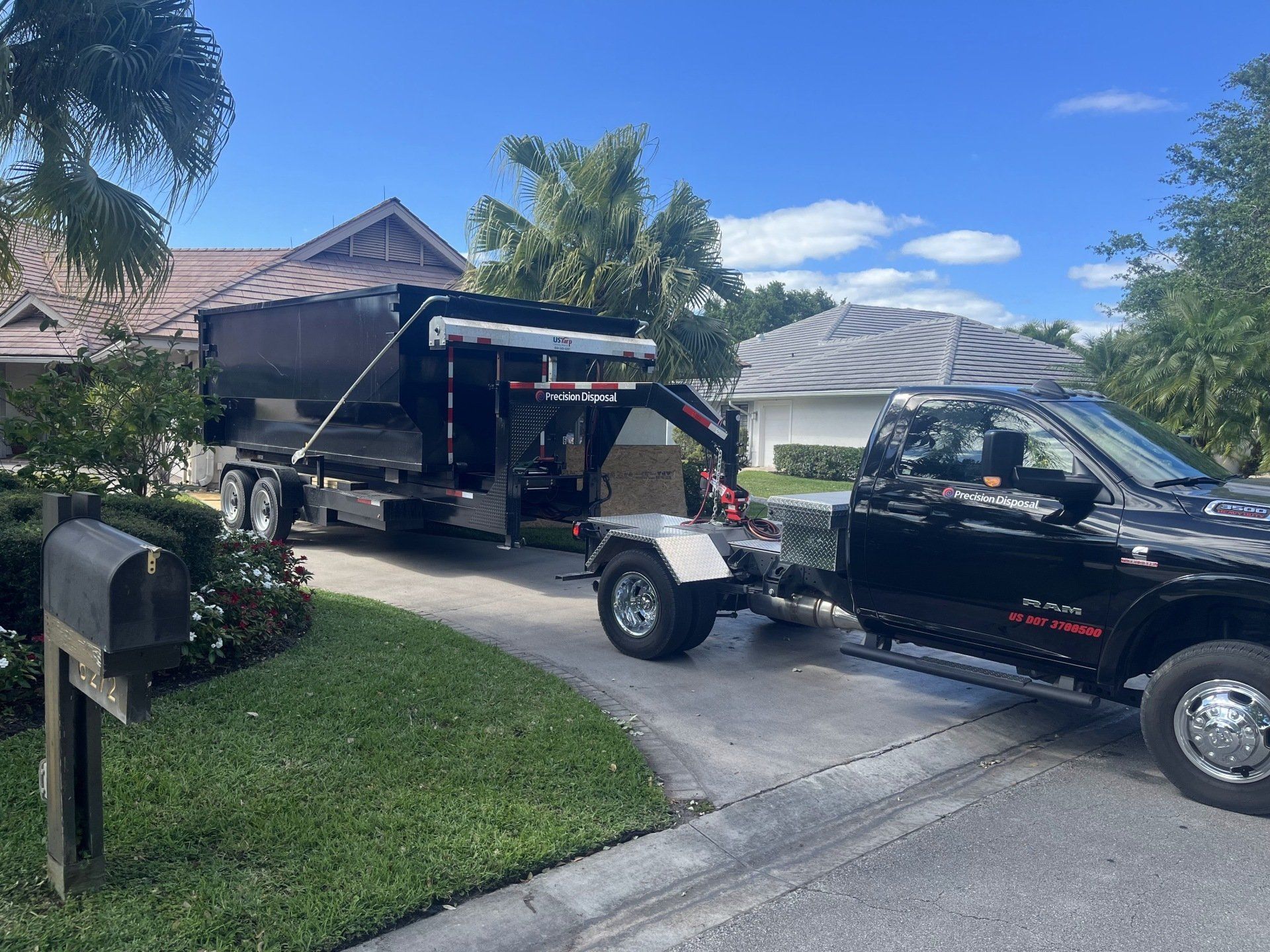Dumpster on trailer attached to truck in driveway