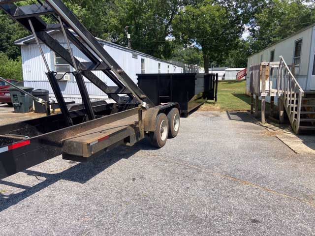 trailer delivering dumpster