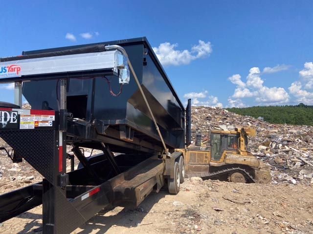 Dumpster offloading waste at a landfill