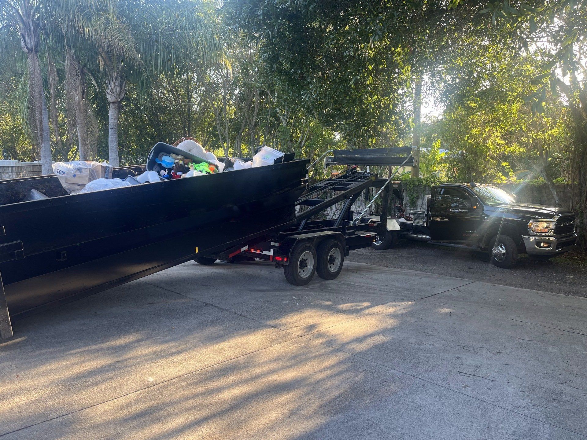 full dumpster loaded onto a trailer to be hauled away