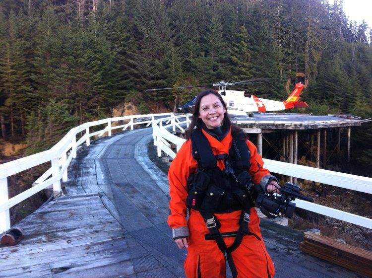 A woman standing on a bridge with a helicopter in the background