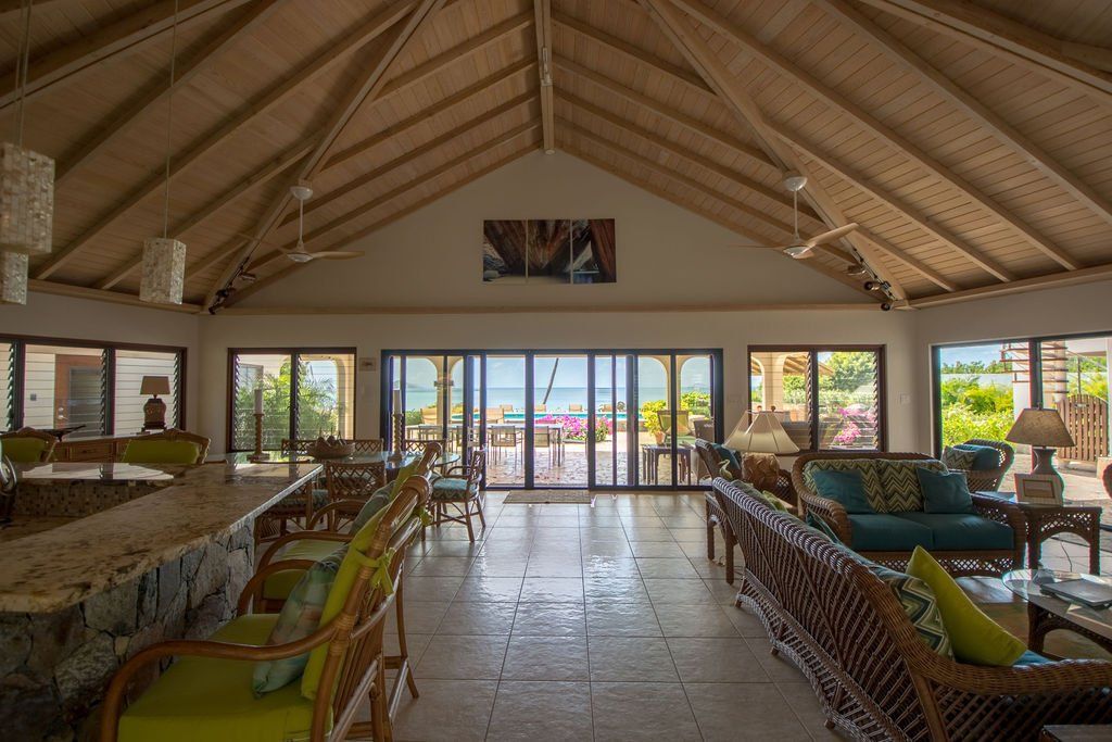 Spacious open-air lounge with tiled floor, high vaulted ceiling at Caribbean Wind villa