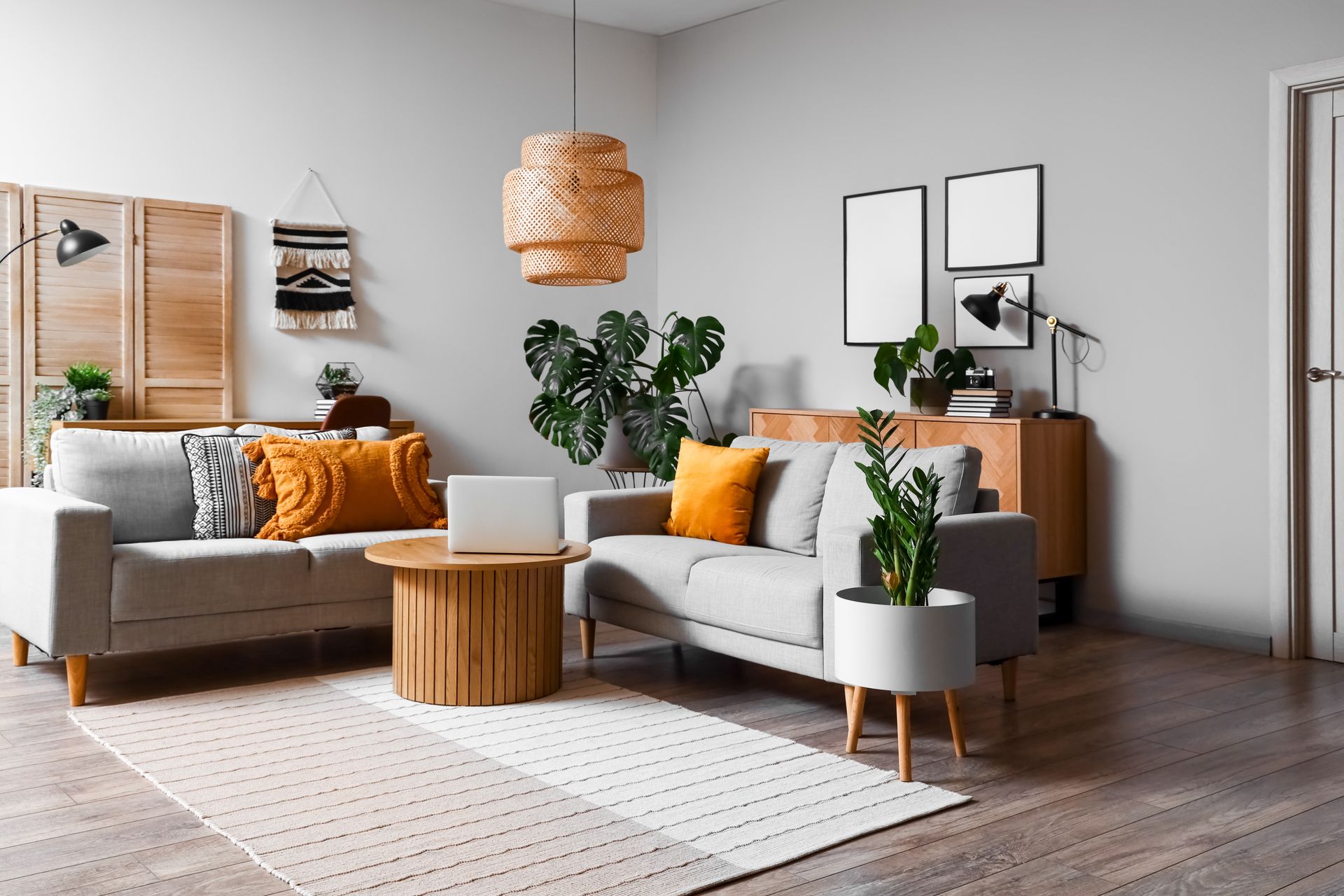 A living room with a couch , two coffee tables , and a laptop.