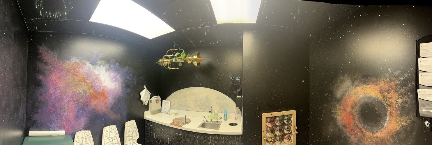 Murals on dark walls, including a sunlit dome and a glowing orange ring, in an indoor art display