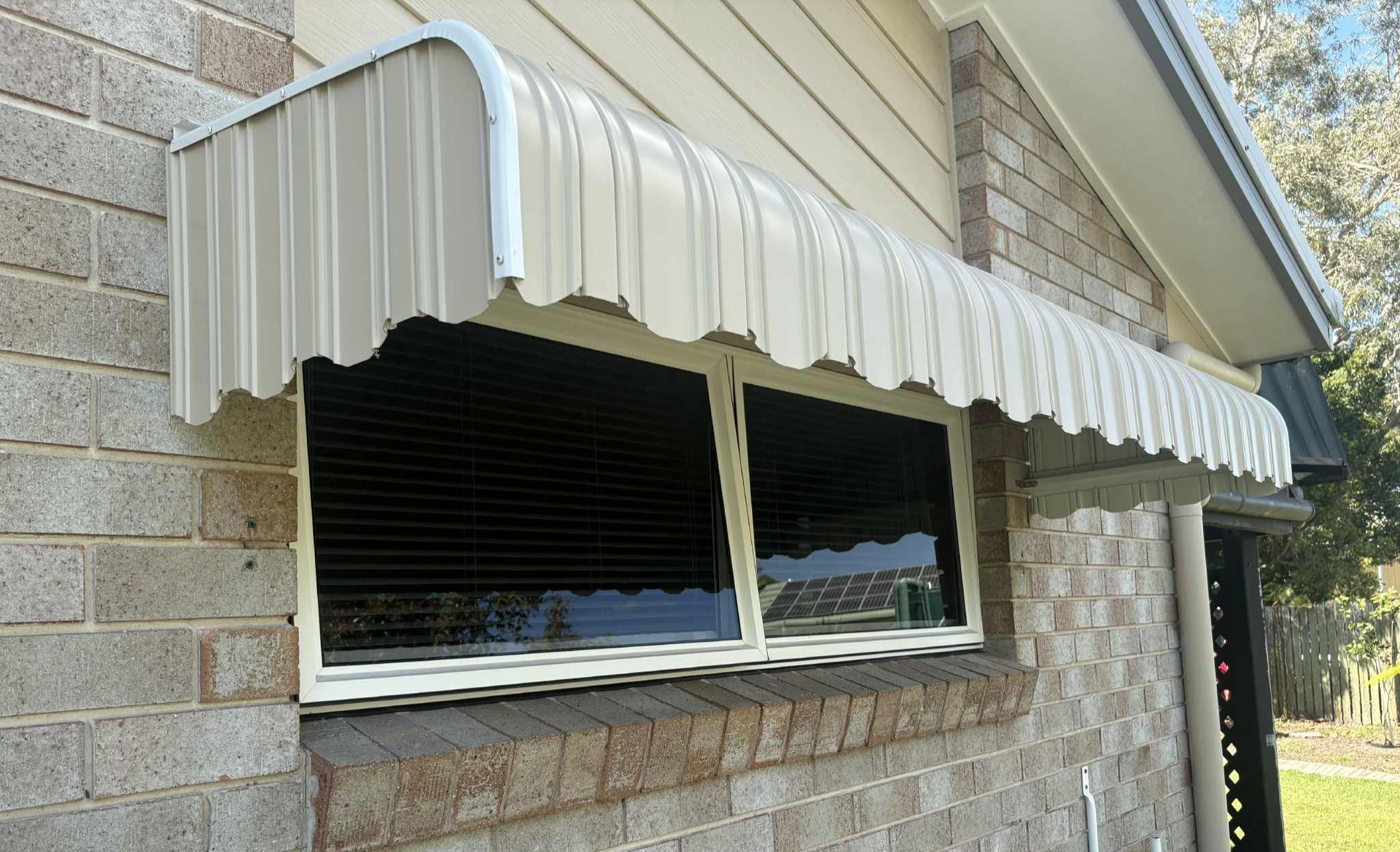 White Awning Over a Brick House Window and Stone Wall — Advantage Screens and Blinds Hervey Bay In Pialba, Queensland