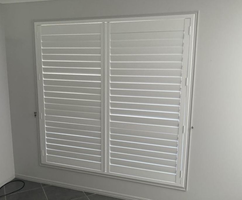 White Window Shutters in A Gray Interior Room — Advantage Screens and Blinds Hervey Bay In Pialba, Queensland