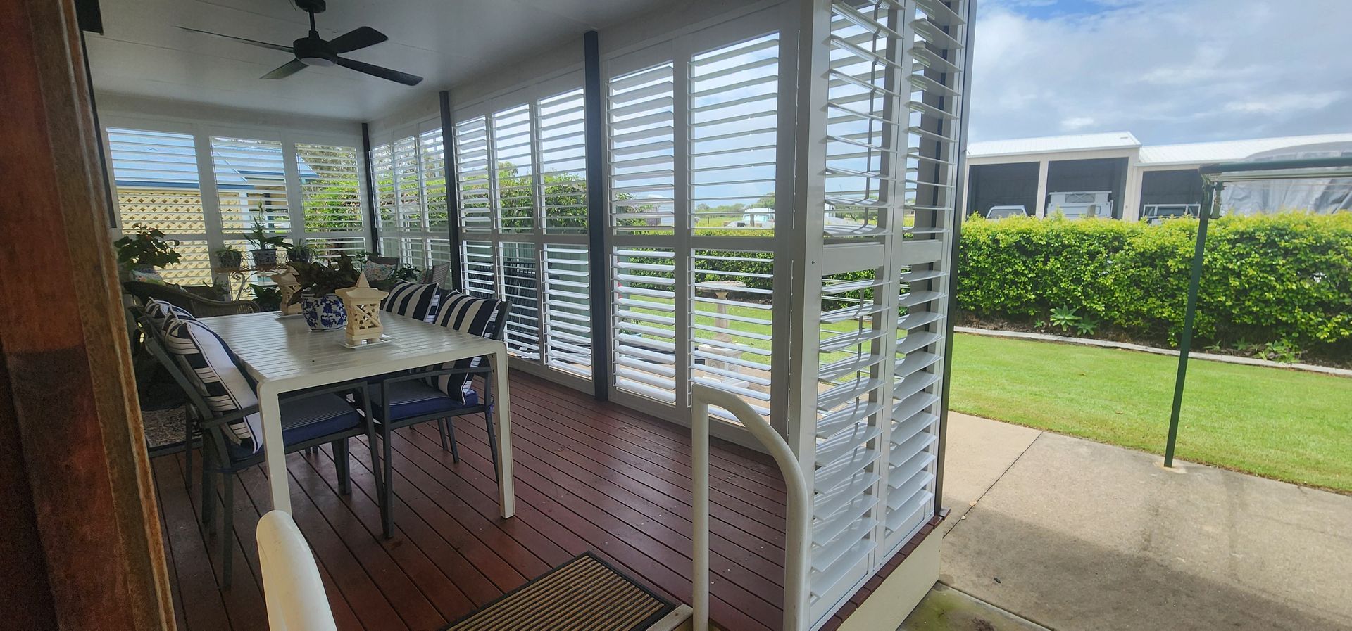 Patio Dining Area with Table and Seen Through White Shutters — Advantage Screens and Blinds Hervey Bay In Pialba, Queensland