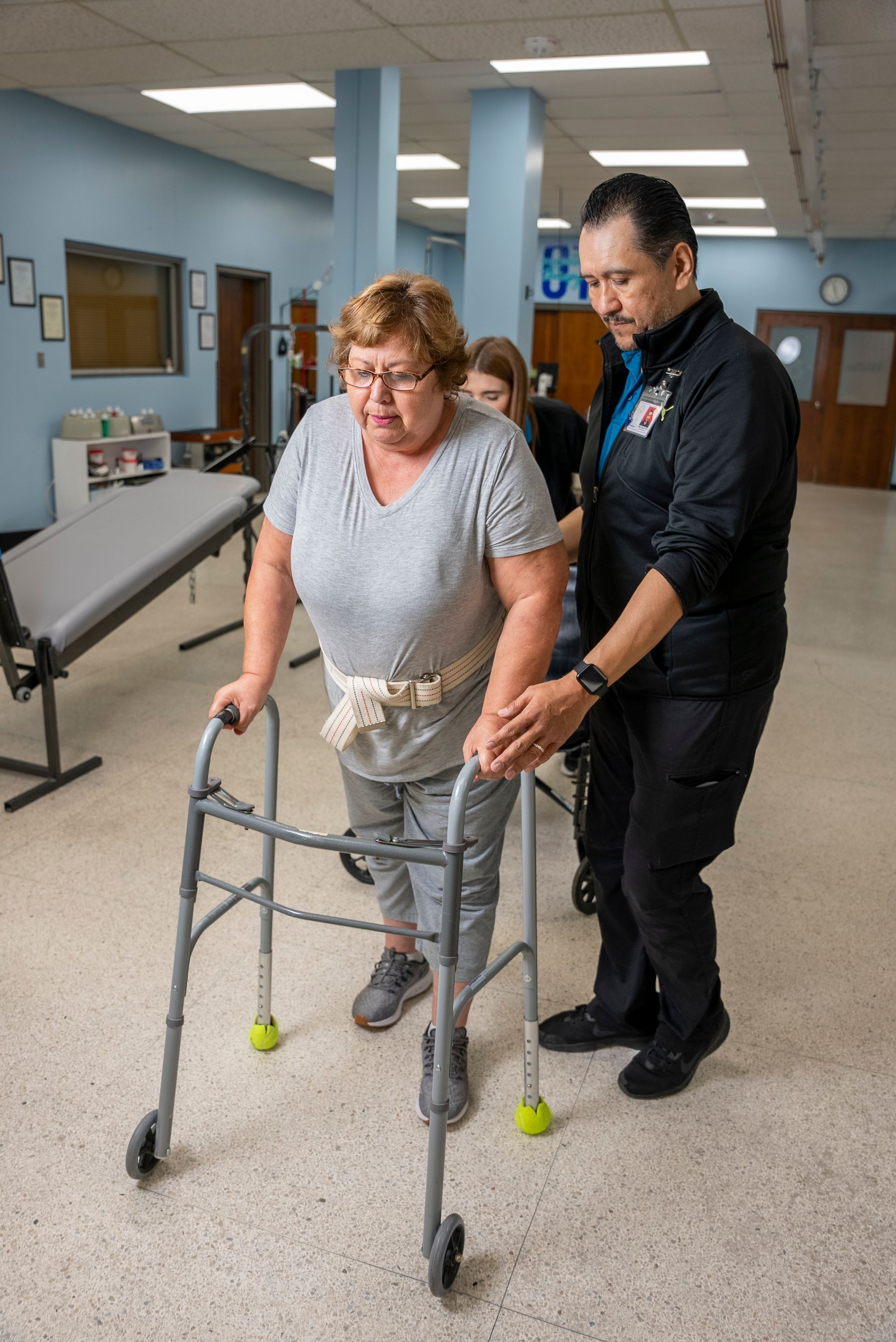 staff member at Ruthe B. Cowl Rehab center assists a patient with her walking.