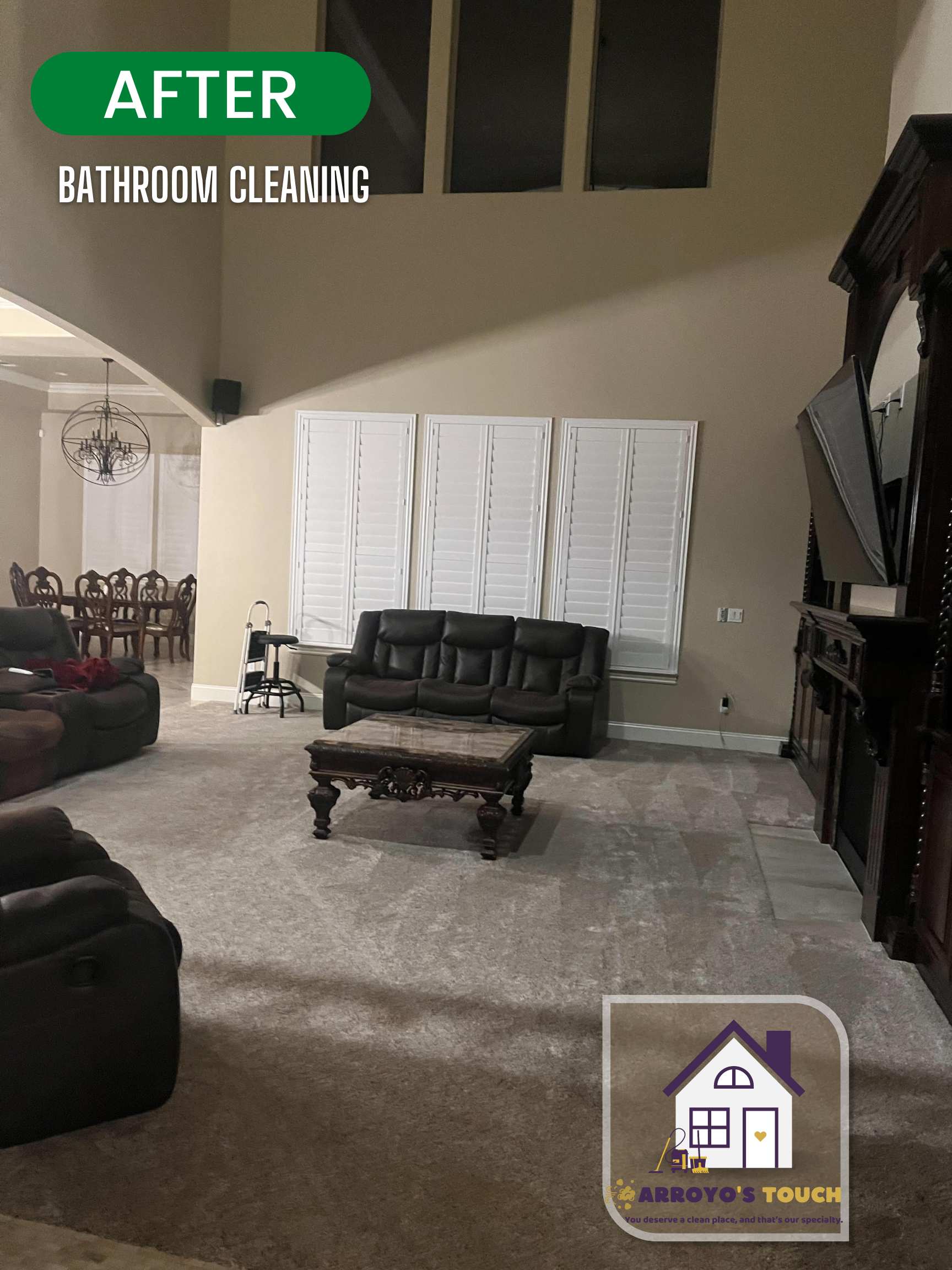 Clean living room with gray carpet, black couch, dark wooden furniture, and high ceilings.