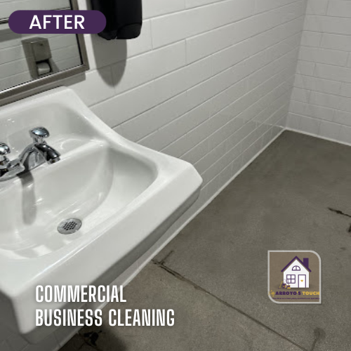 Clean white sink and tiled wall in a commercial restroom, concrete floor.