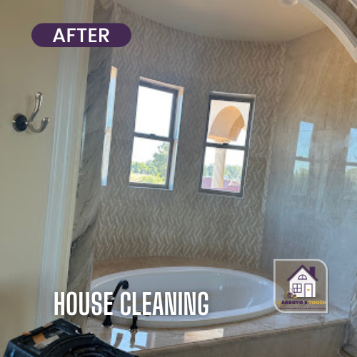 Bathroom after cleaning: Oval tub, patterned wall, windows, neutral colors.