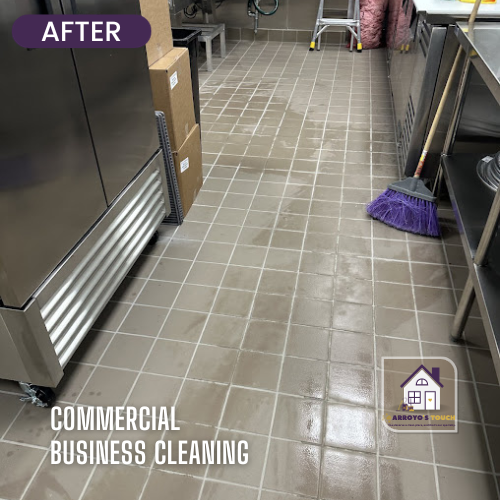 Cleaned commercial kitchen floor after service with equipment and broom.