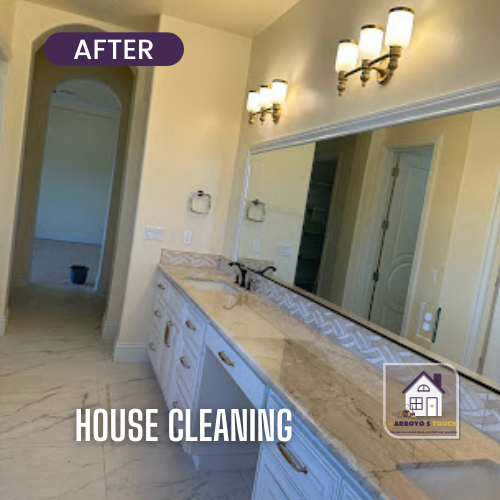 Bathroom with white cabinets, long marble countertop, large mirror, and three light fixtures.
