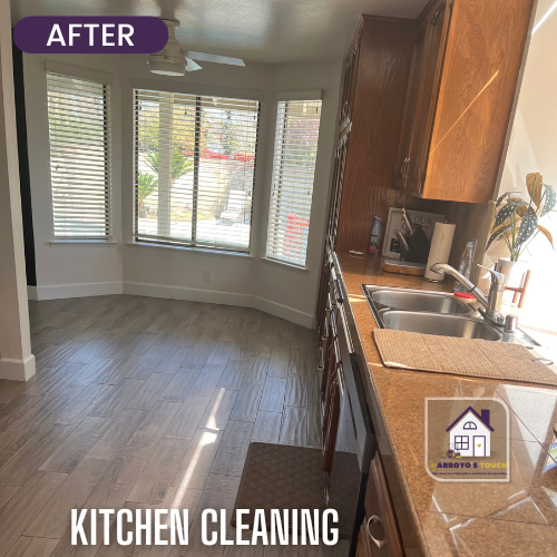 Clean kitchen with a bay window. Brown cabinets, tan counters, light wood floor.