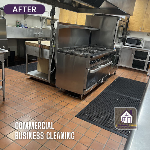 Clean commercial kitchen with stainless steel appliances and red tile flooring.