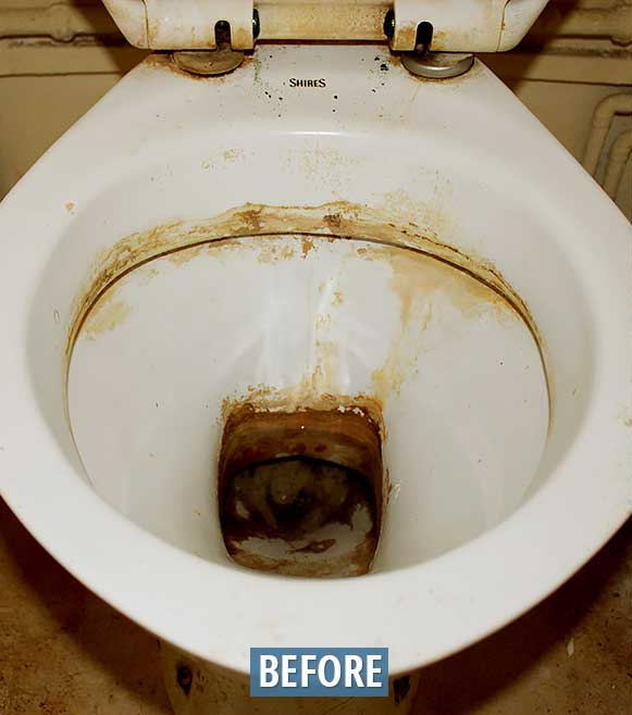 A dirty white toilet bowl with brown stains and buildup; 