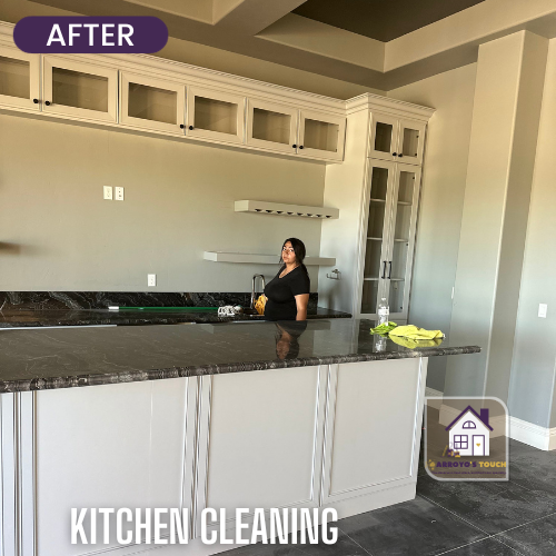 Kitchen with grey countertops and cabinets. Person cleaning.
