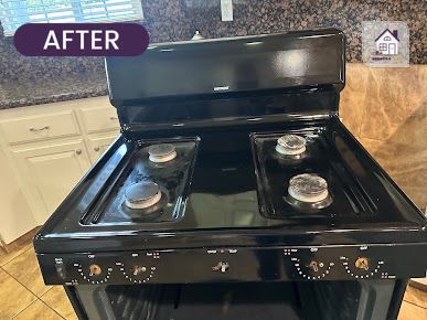 Black stovetop, recently cleaned, with four burners, in a kitchen. The word