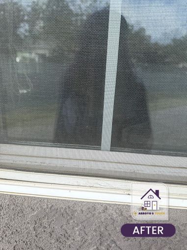 Close-up of a clean window screen, part of a house.
