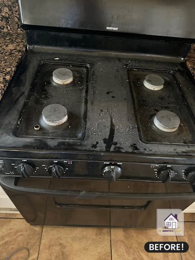 Black gas stove with dirty burners and cooktop, before cleaning.
