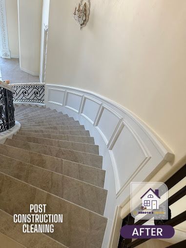 Curved staircase after post-construction cleaning; light beige walls, white trim, stone steps.