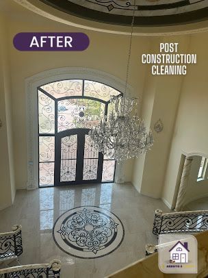 Entryway after post-construction cleaning. Features a chandelier, ornate door, and marble floor with a decorative inlay.