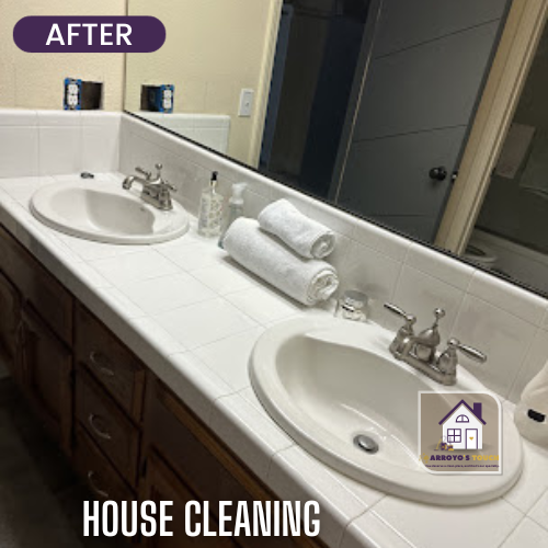 Cleaned bathroom countertop with two sinks, towels, and a mirror.