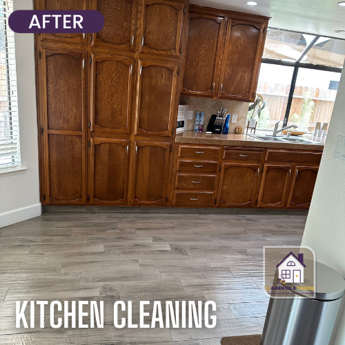 A clean kitchen with wood cabinets, new flooring, and a large window.