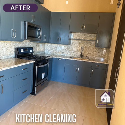 Kitchen with gray cabinets, granite countertops, and a stove after cleaning.