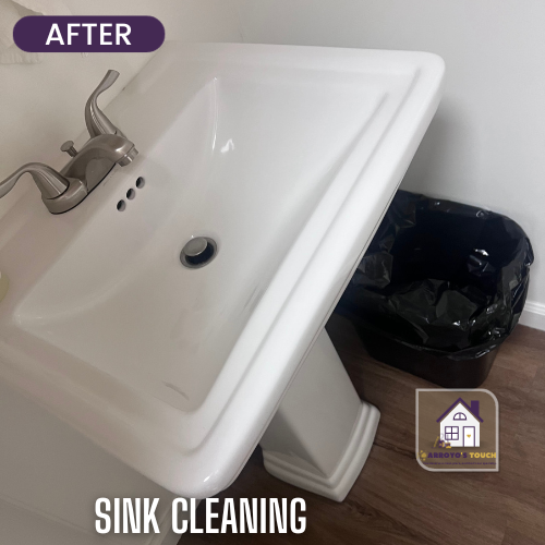 Clean white sink after cleaning, with faucet, trash can, and wood floor.