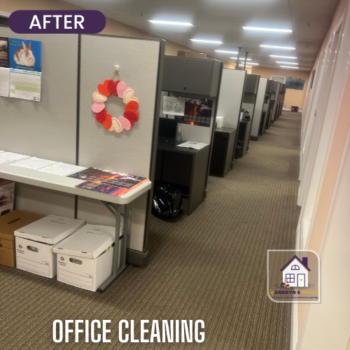 Cleaned office space with cubicles, a folding table, and boxes. Neutral carpet and lighting.