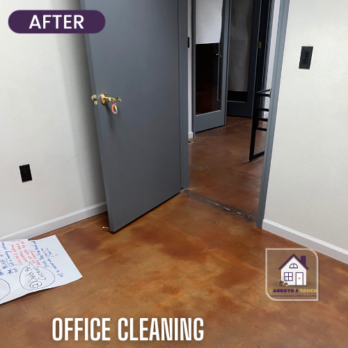 Office with brown stained concrete floor, gray door, and white walls. After cleaning.