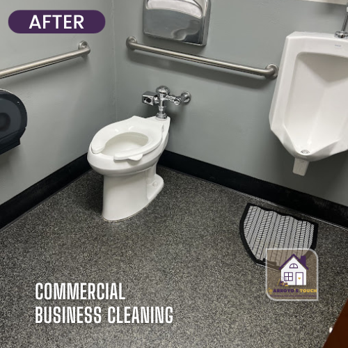 Clean commercial restroom with toilet, urinal, and grab bars. Gray walls and flooring.