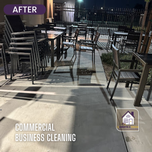 Nighttime outdoor patio after cleaning, with tables and chairs, concrete, and a fence.