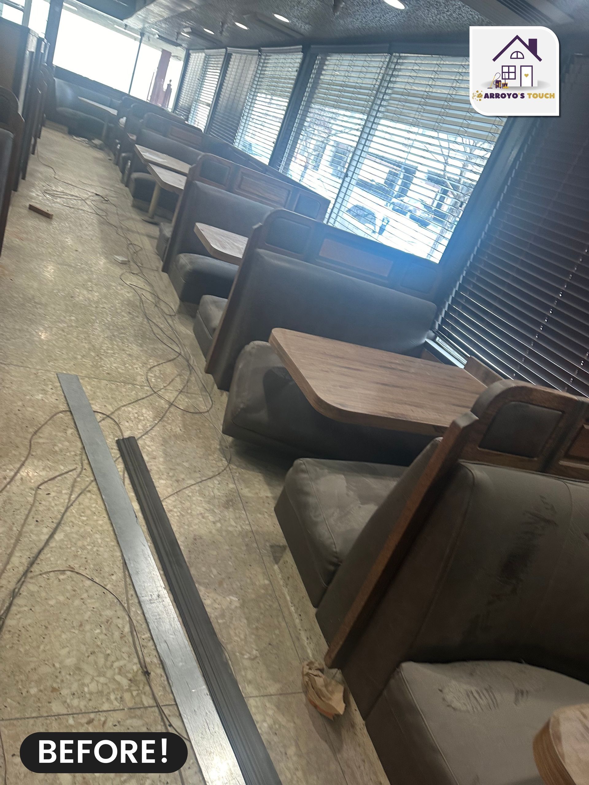 Empty restaurant booths and tables, dusty and worn. Large windows with blinds. 