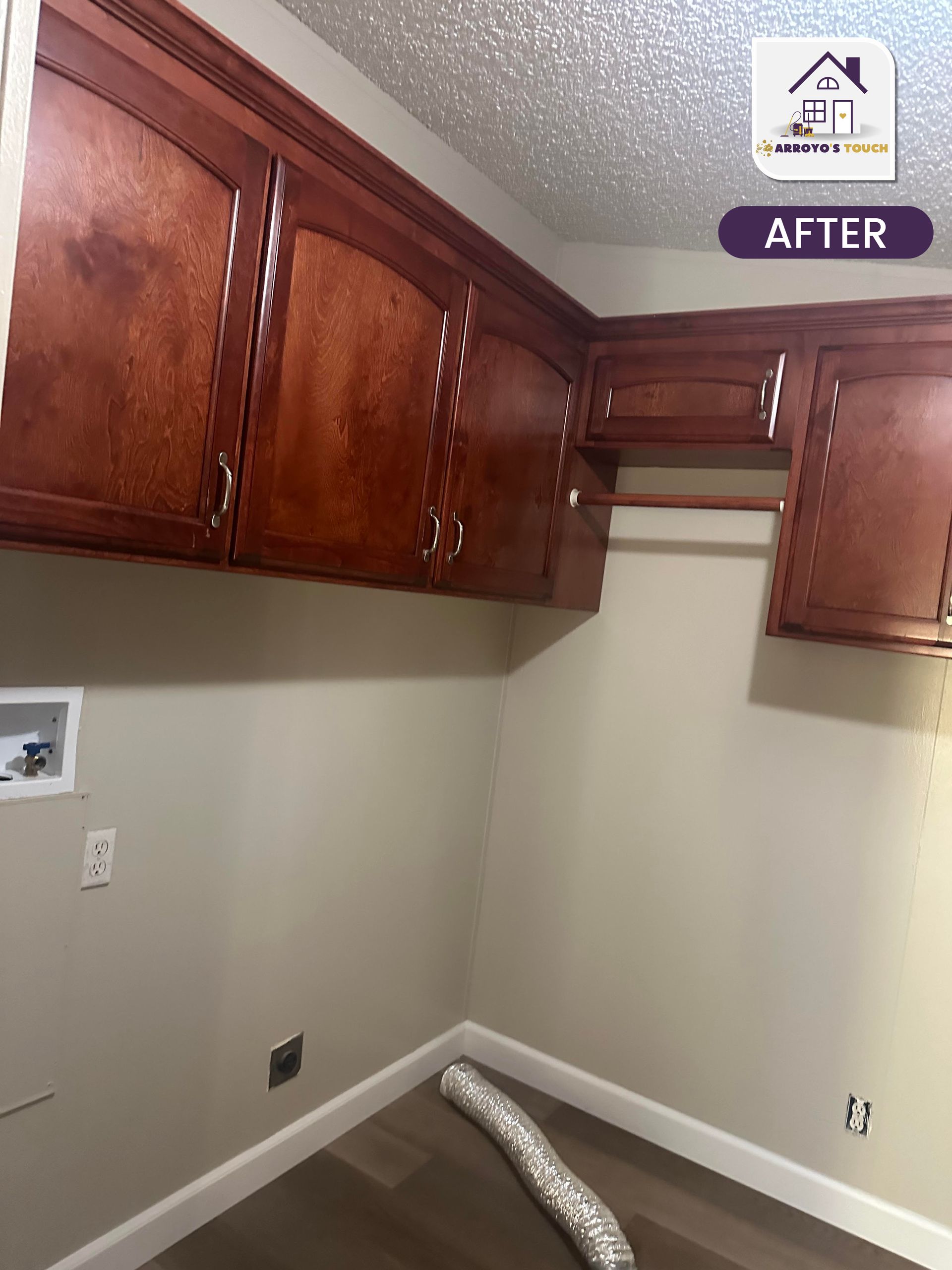 Laundry room with dark wood cabinets, tan walls, and a clothes rod.