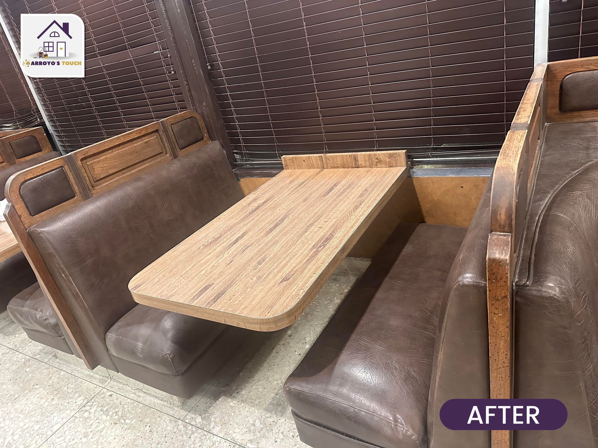 Booth seating in a diner; brown leather, wooden tables, and dark blinds.
