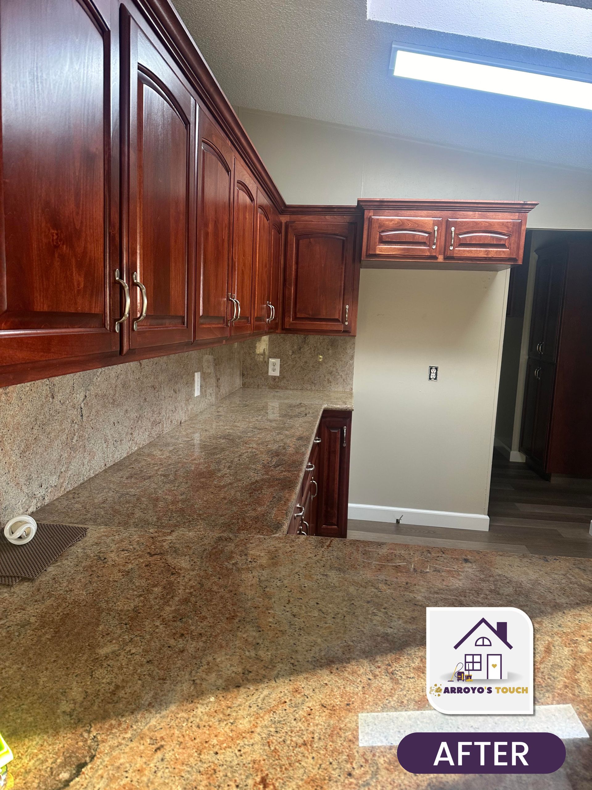 Cherry-stained kitchen cabinets with granite countertops. 