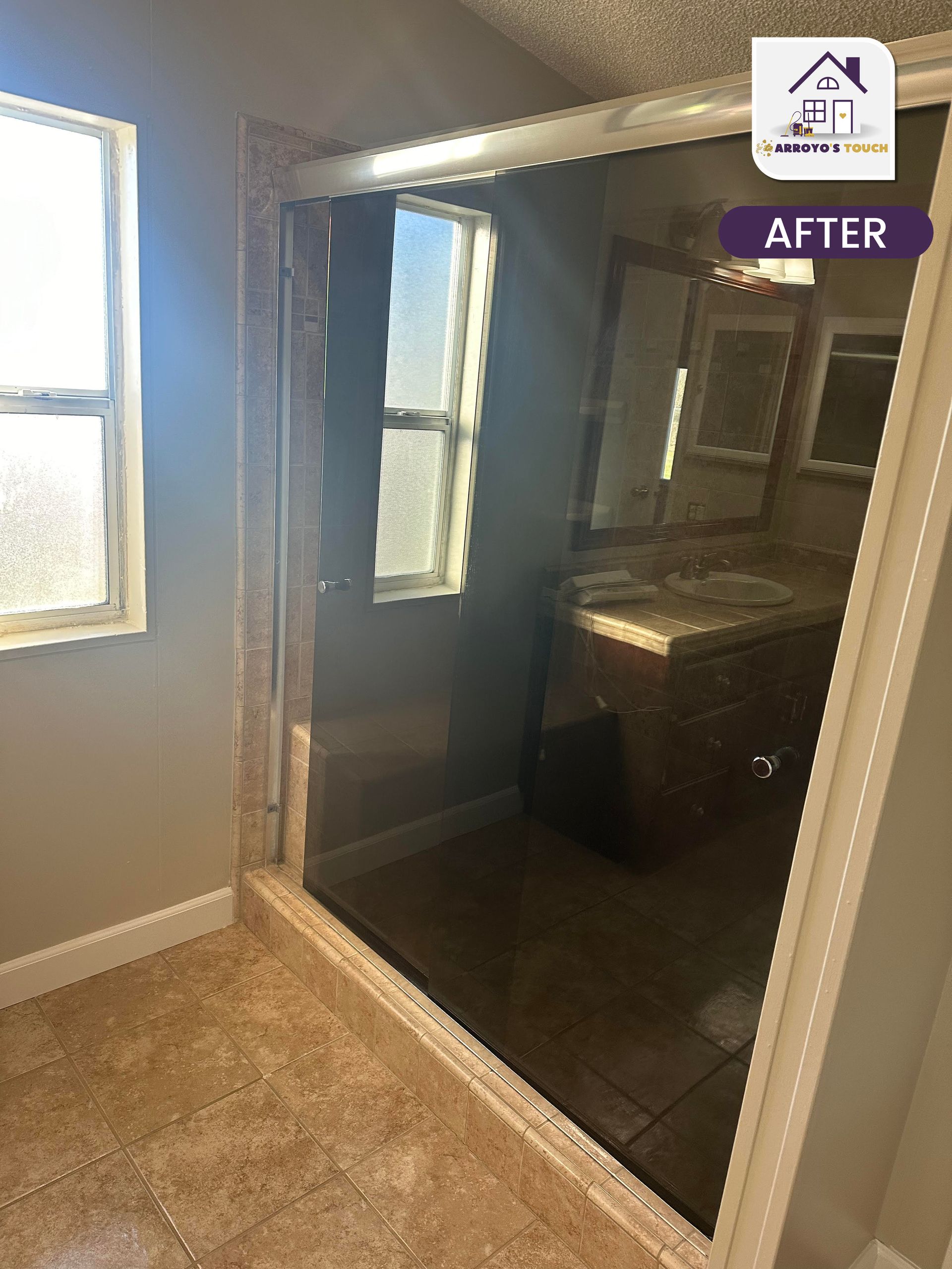 Bathroom renovation: New glass shower enclosure with vanity and tile floor.