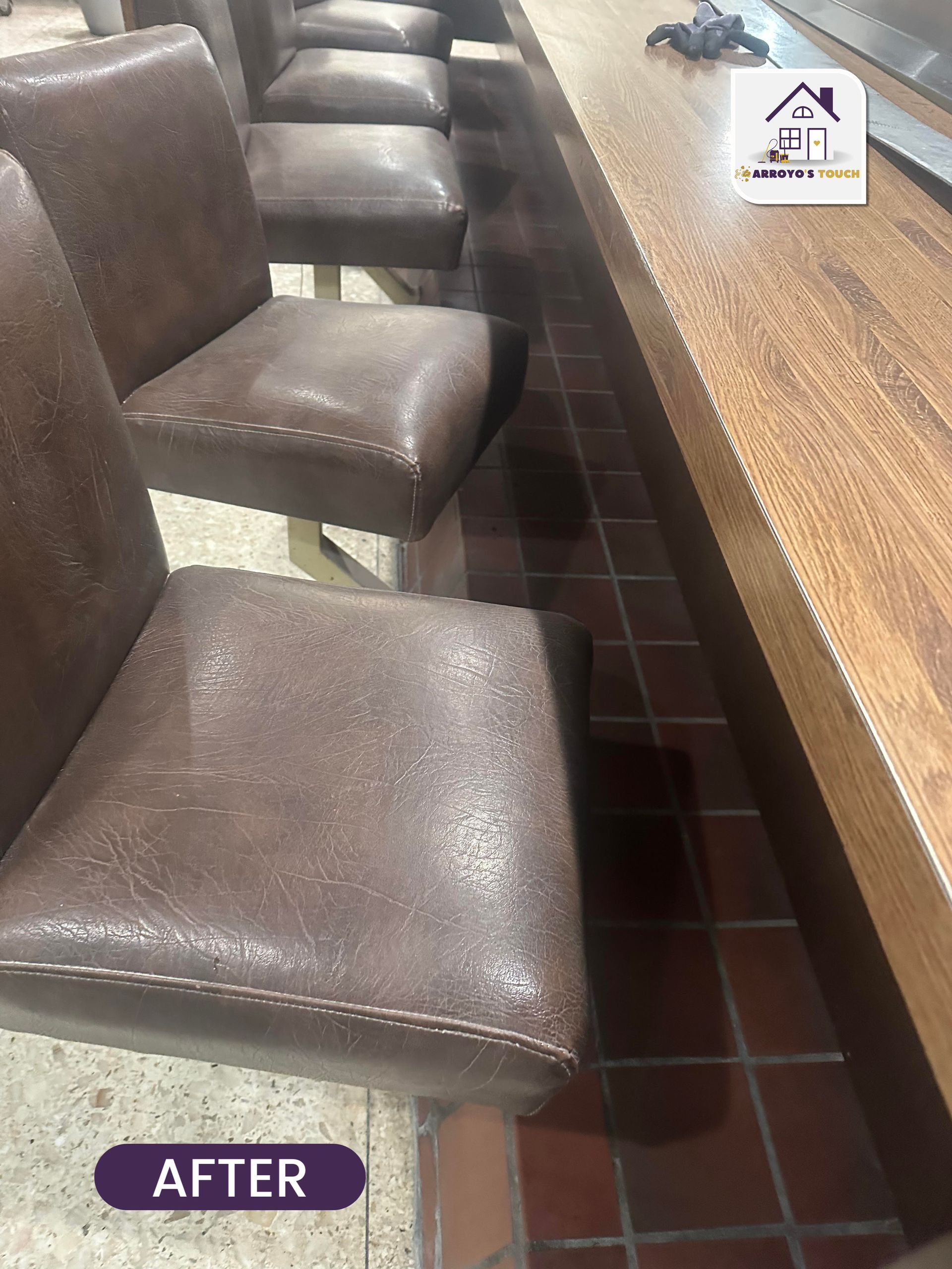 Brown leather bar stools line a wooden counter. Red tile flooring. 